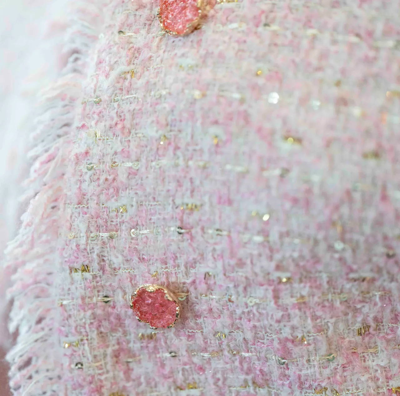 Close-up of a pink textured jacked with pink buttons.